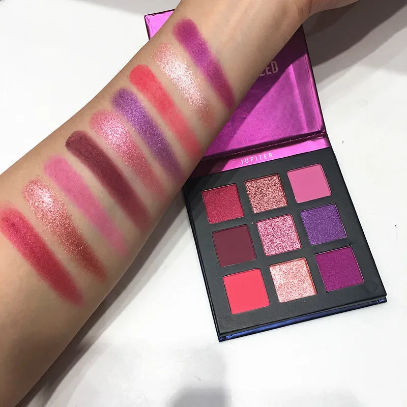 Eyeshadow palette featuring nine colors in shimmer and matte finishes, with swatches on a hand showing vibrant pinks and p...