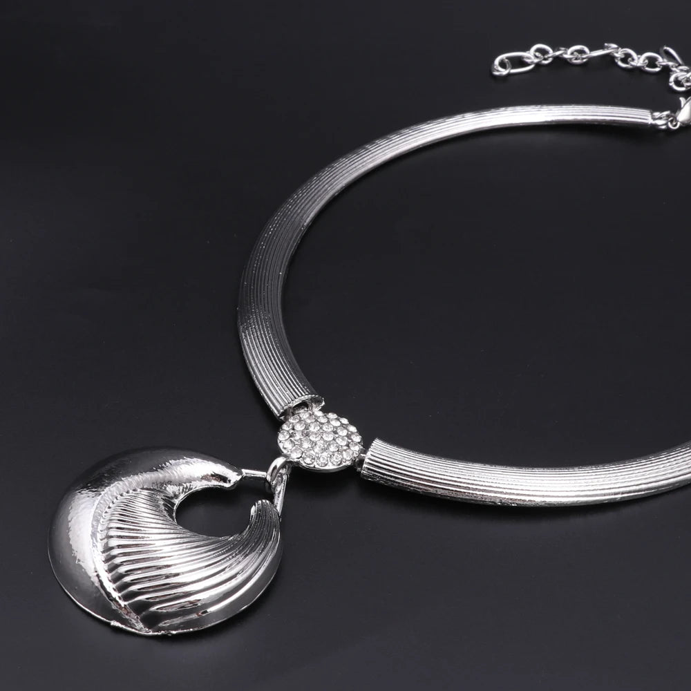 Silver plated luxury necklace featuring a textured crescent pendant and a chain link closure.