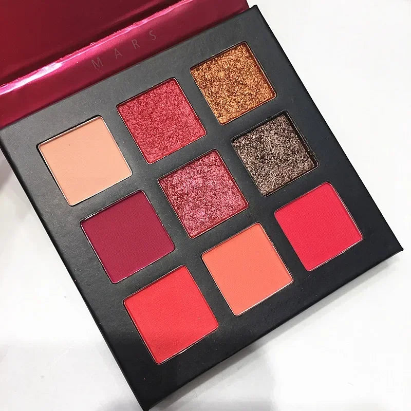 Nine-color eyeshadow palette featuring shimmer and matte shades in pink, red, and brown tones arranged in a square layout.